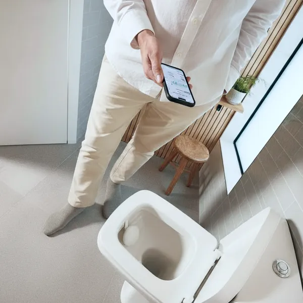 Personne se préparant un jus frais le matin dans une cuisine lumineuse, illustrant une routine santé positive